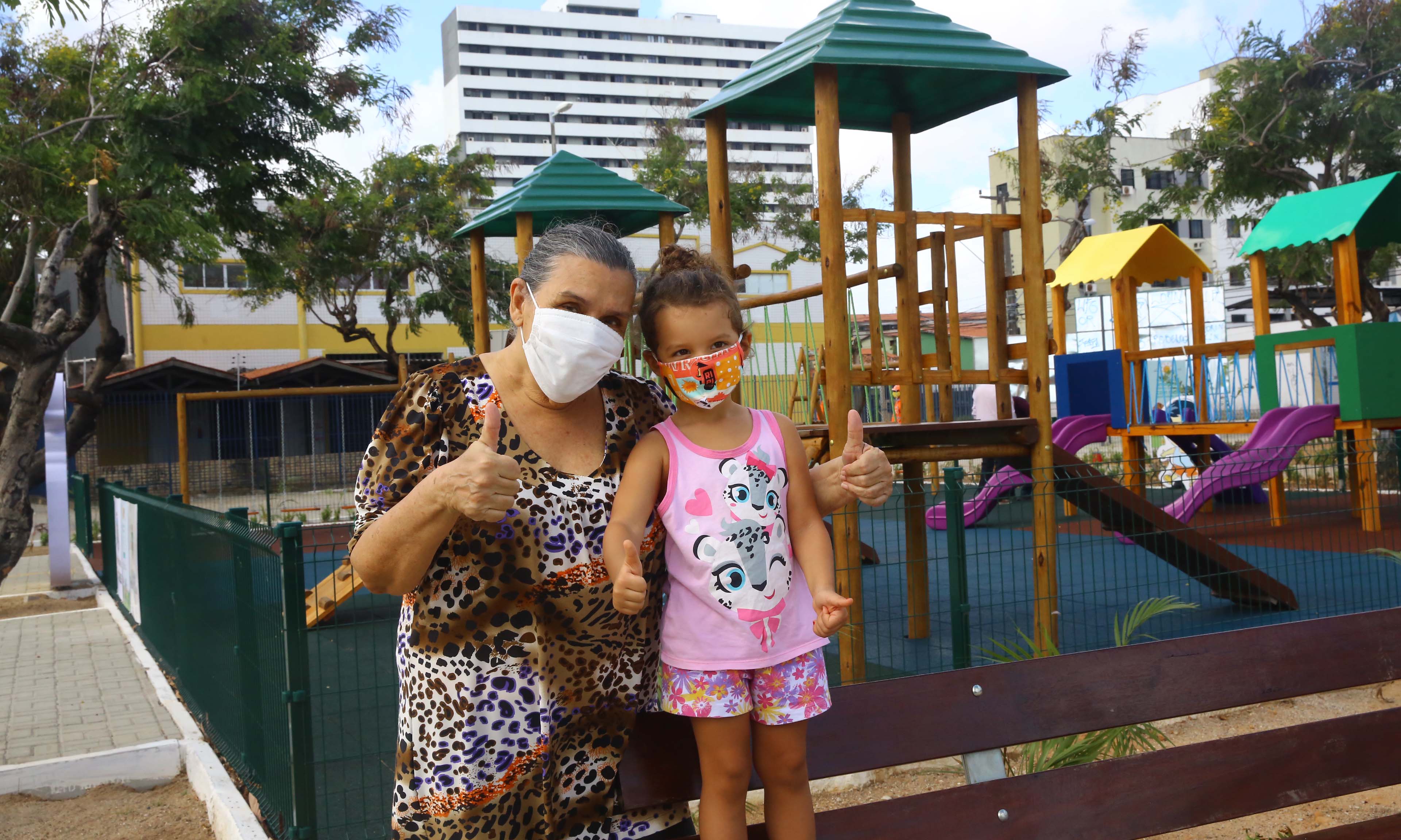 senhora acompanhada de uma criança, ambas usam máscara